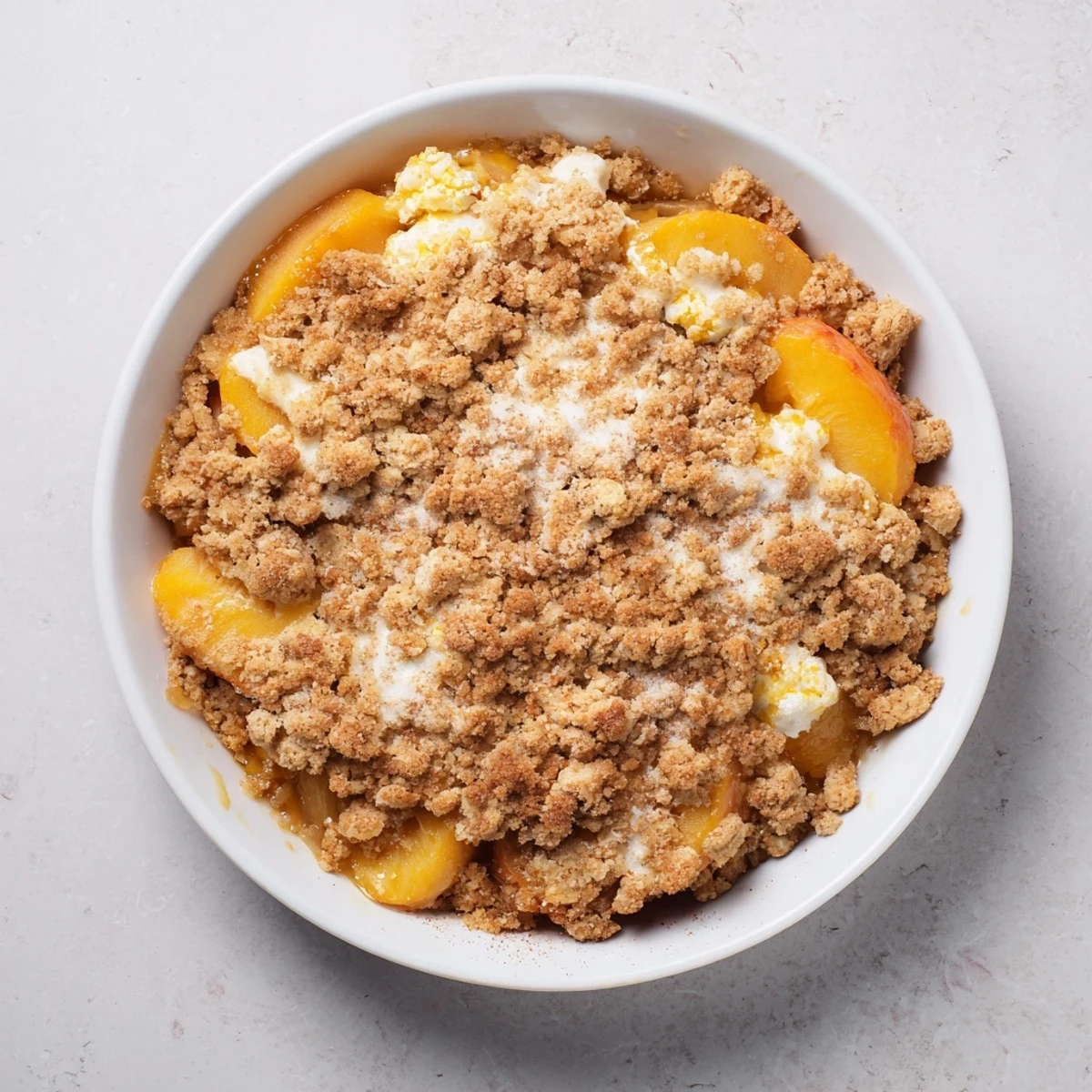 Golden, bubbly Peach and Ginger Crumble, a warm delight with sweet peaches and spiced crumble.