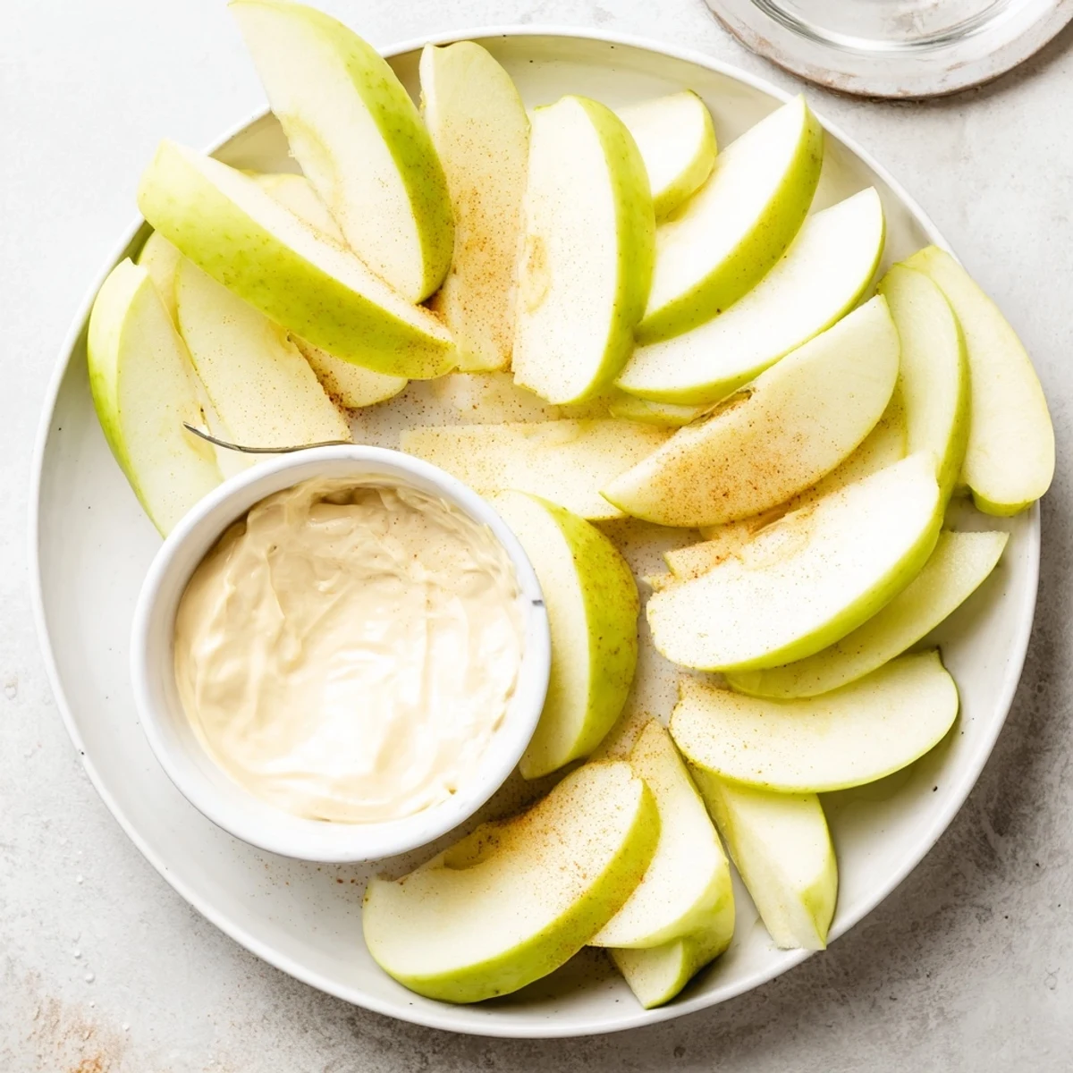 Fresh apple slices ready for dipping into a smooth, cinnamon-kissed peanut butter.