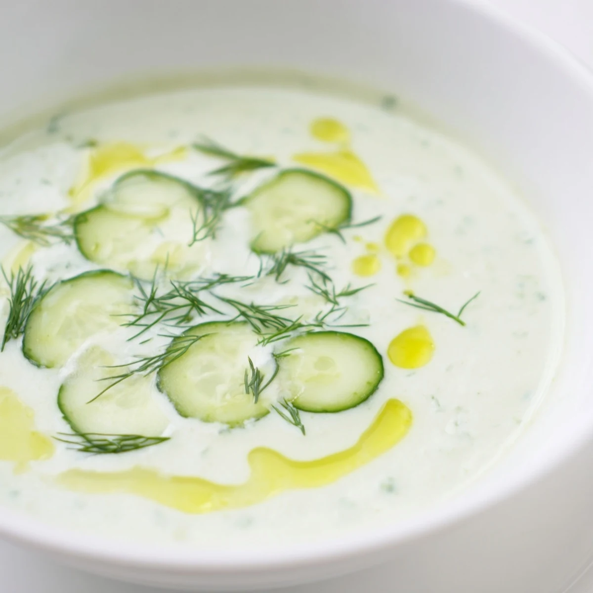 Creamy, cold Chilled Cucumber Garlic Soup, a perfect summer starter with a swirl of olive oil.