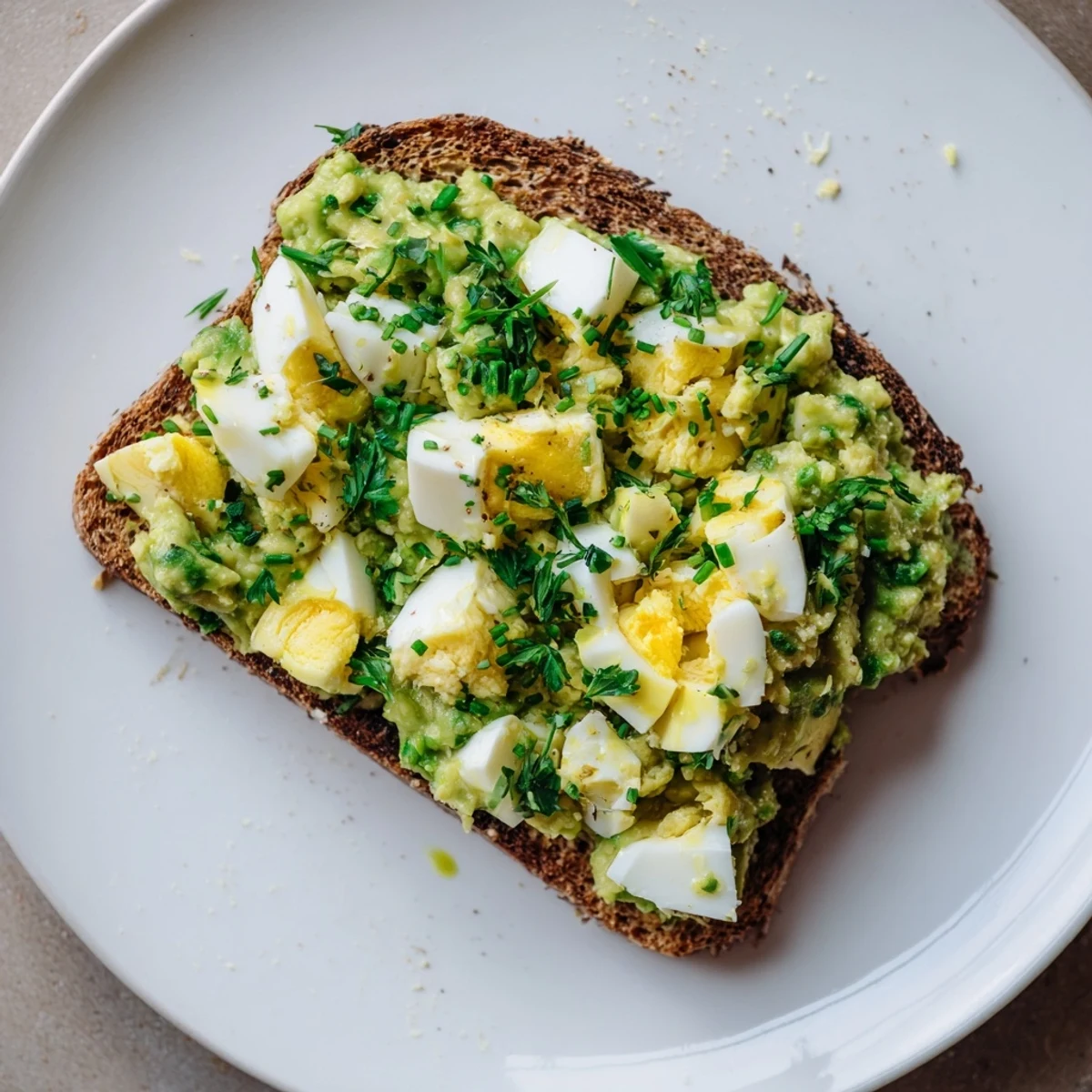 A vibrant close-up shows avocado egg smash, ready for spreading on golden toast.
