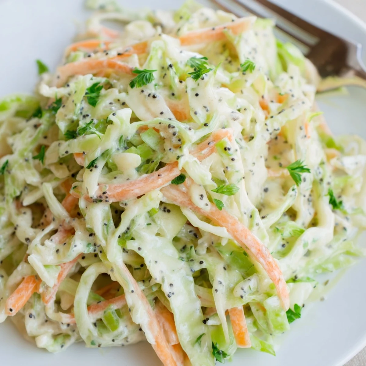 A close-up of vibrant green cabbage and apple slaw in a rustic bowl, topped with fresh parsley and poppy seeds for texture.