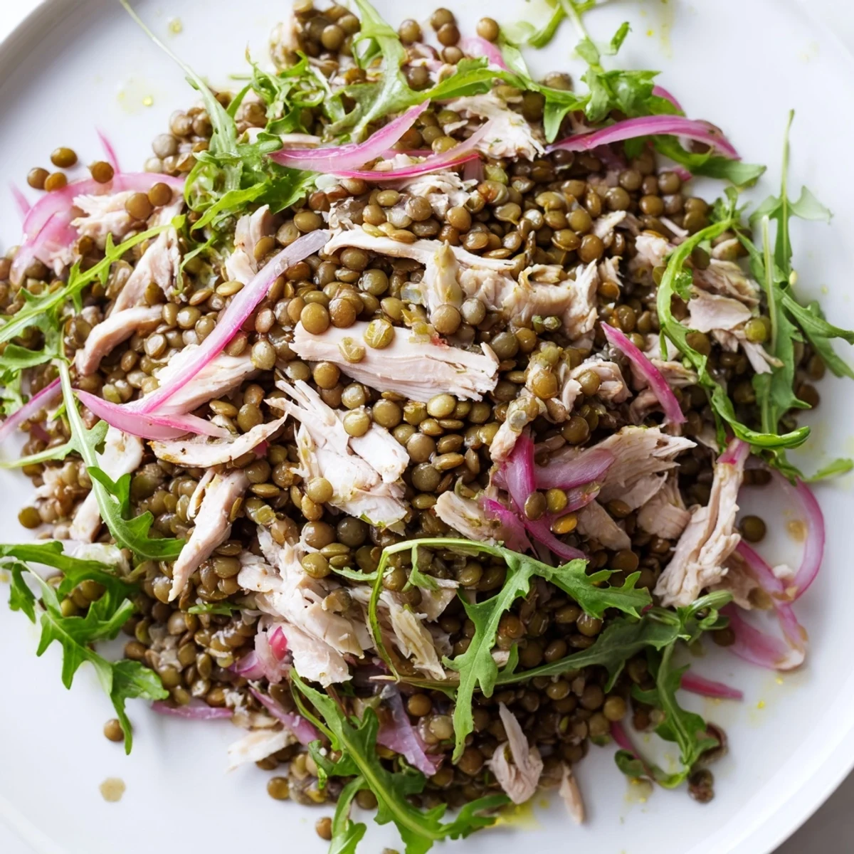 A vibrant bowl of Lentil & Chicken Spring Salad featuring peppery greens, pickled onions, and cherry tomatoes for a refreshing, protein-packed meal.