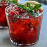 Refreshing raspberry lemon spritz mocktail with sparkling water, muddled berries, and zesty citrus served over ice.