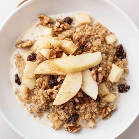 Steaming Apple Cinnamon Quinoa Bowl, a comforting vegetarian breakfast with fresh apples and spice.