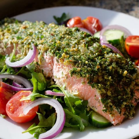 Warm, flavorful herb-crusted salmon nestled on a bed of fresh greens for this delicious salad dish.