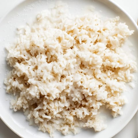 Steaming bowl of Coconut Jasmine Rice, fragrant and slightly sweet, perfect texture achieved.