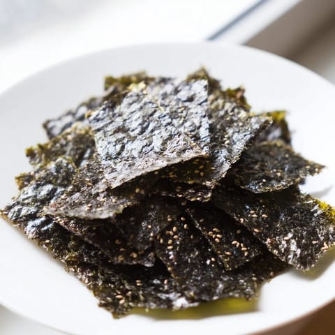 Golden-edged roasted seaweed chips cooling on a tray, perfect for snacking or topping rice bowls.  