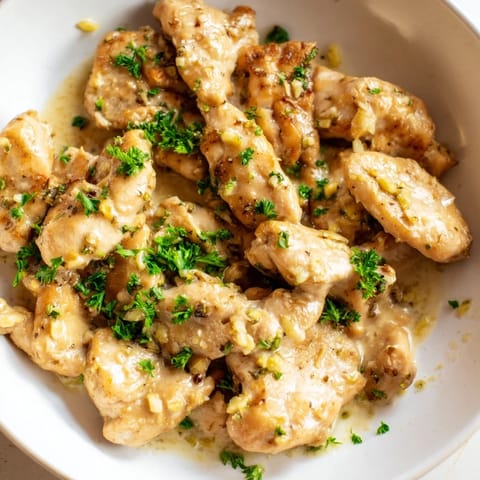 Tender bite-sized chicken pieces coated in a luscious garlic Parmesan cream sauce, perfect for a quick weeknight dinner served over steamed pasta.