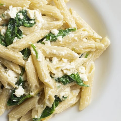 Steaming bowl of Creamy Feta Spinach Pasta garnished with lemon zest and herbs, ready to serve as a comforting main dish.