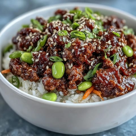 Colorful Korean Ground Beef Bowl topped with sesame seeds and bright, spicy kimchi garnish.