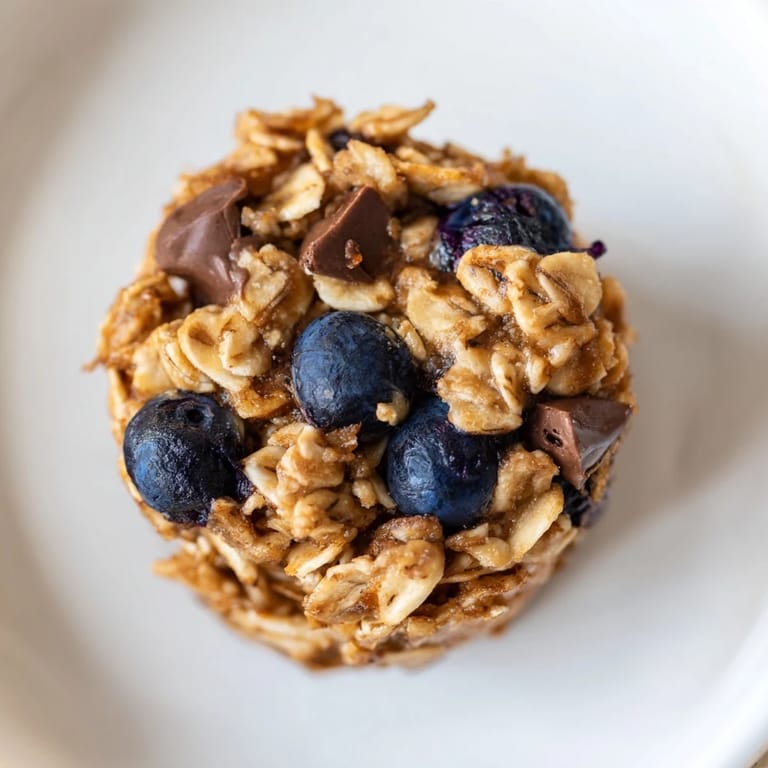 Warm, freshly baked Baked Oatmeal Cups, offering a sweet aroma and a delightful chewy texture, ready to eat.