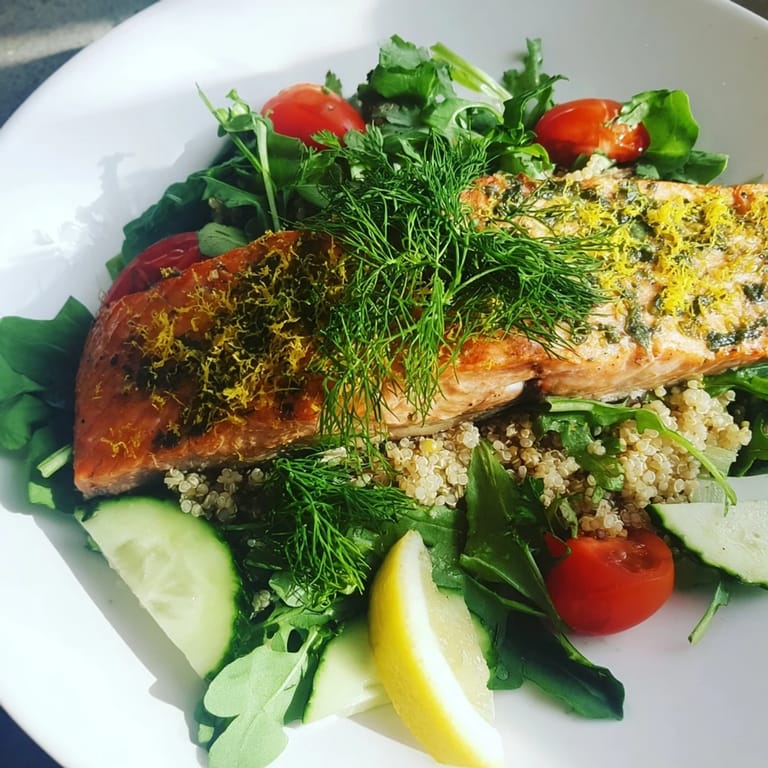 Warm Lemon Herb Salmon Salad featuring flaky fish atop quinoa, greens, and a zesty vinaigrette.