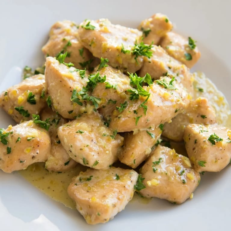 Sizzling Creamy Garlic Chicken Bites fresh from the skillet, featuring a velvety garlic cream sauce and a sprinkle of chopped parsley for garnish.