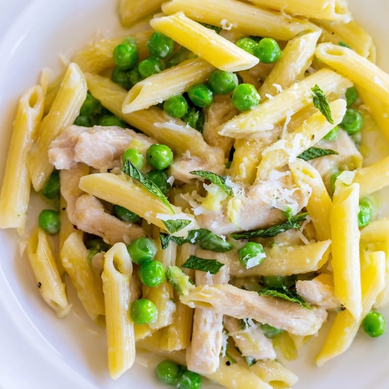 Colorful spring-inspired Pea & Mint Chicken Pasta with peas, herbs, and melted butter for serving.