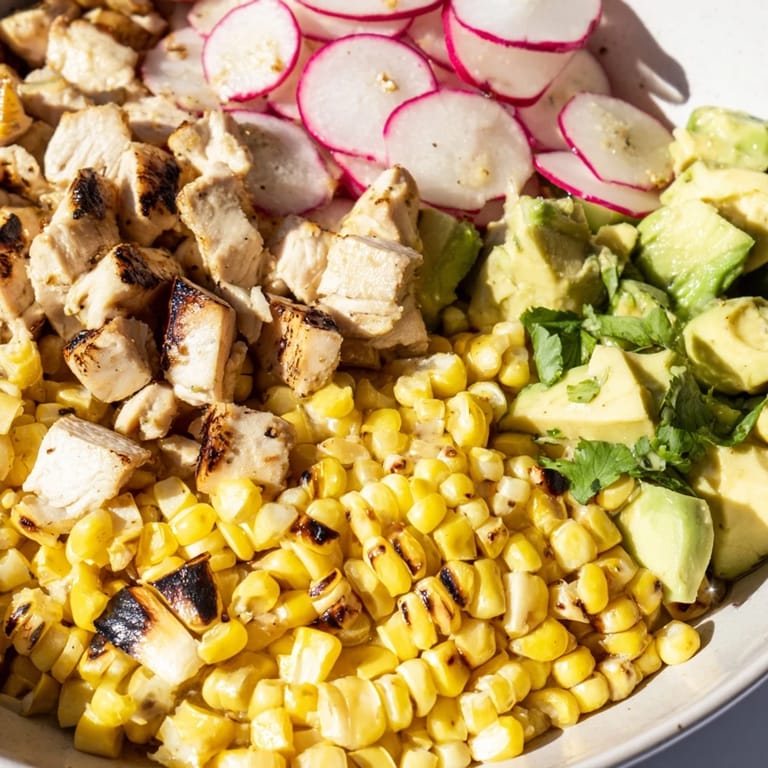 Freshly tossed Roasted Corn & Chicken Chopped Salad with tender chicken, smoky grilled corn, crisp radishes, and creamy avocado, ready to serve.