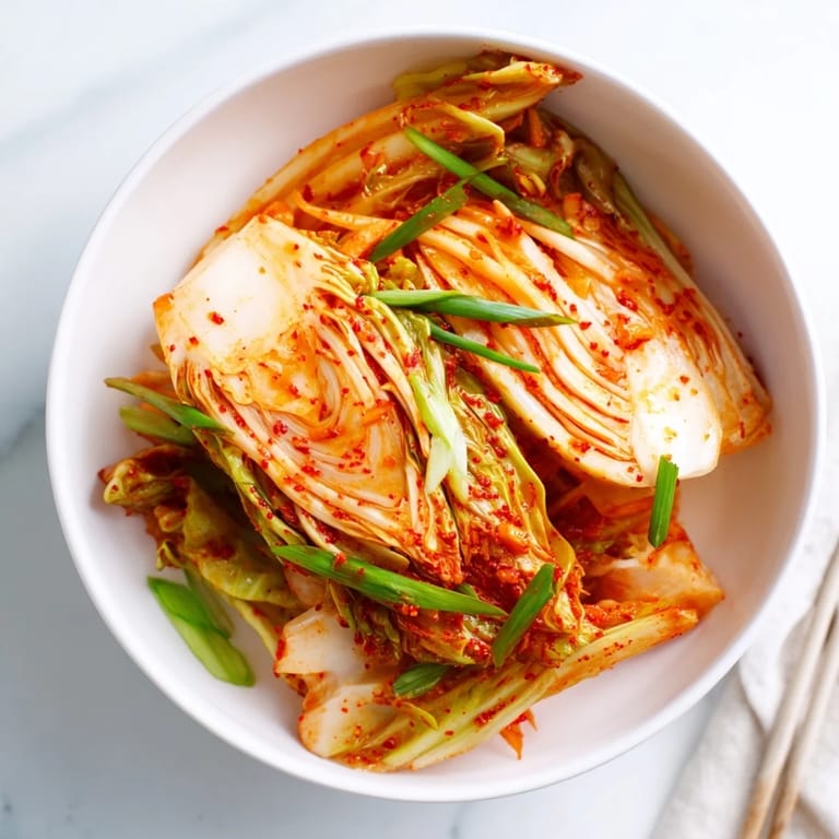 Crunchy vegan kimchi made with napa cabbage and radish, seasoned with ginger and Korean chili flakes, served as a probiotic-rich side dish for grilled meats.