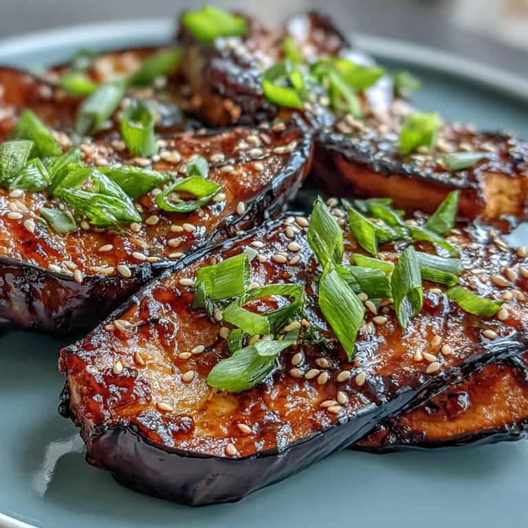 Silky Miso Glazed Eggplant halves, topped with sesame seeds and green onions.