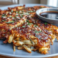 Crispy Cabbage Kimchi Pancakes sizzling in a hot skillet, golden brown and packed with tangy kimchi flavor.